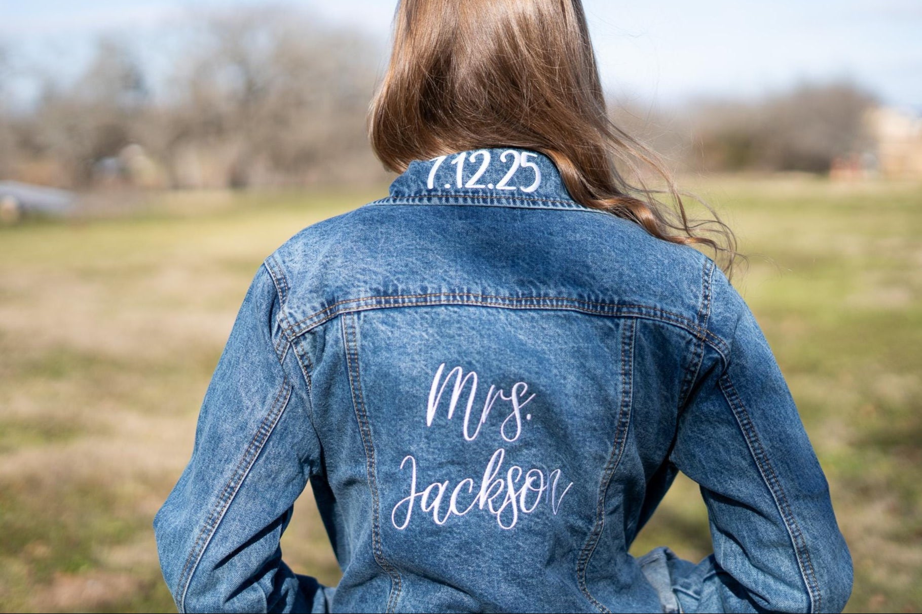 a woman wearing a jean jacket with a name on it