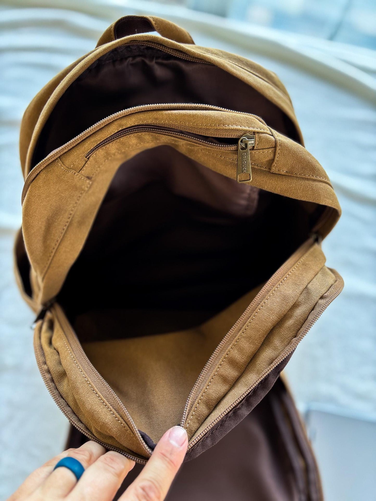 a woman's hand holding a brown purse