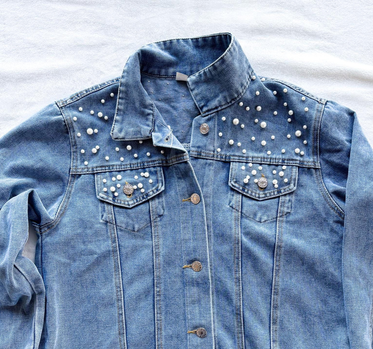 a denim jacket with studded buttons on it