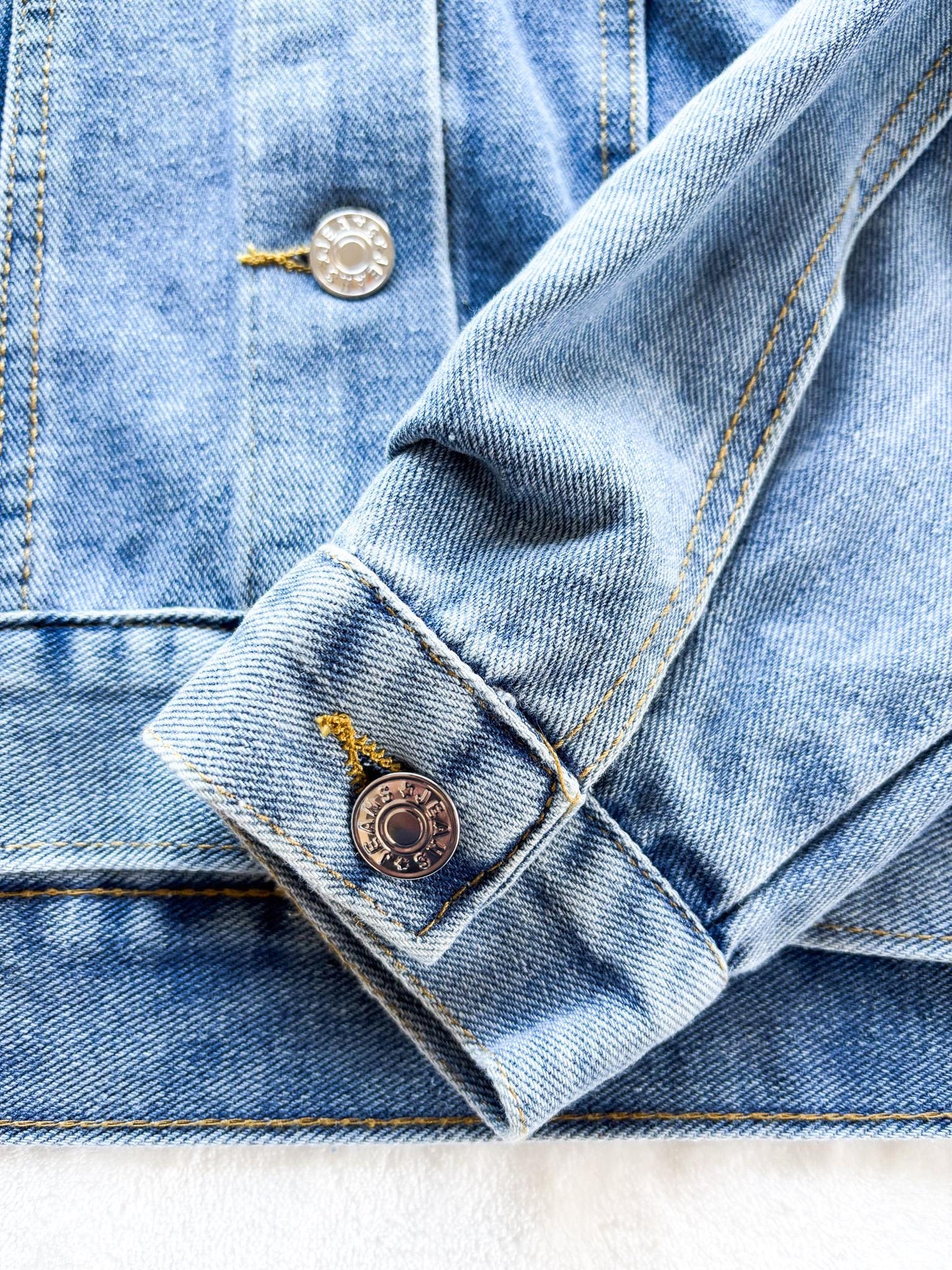 a denim jacket with a button on the back of it