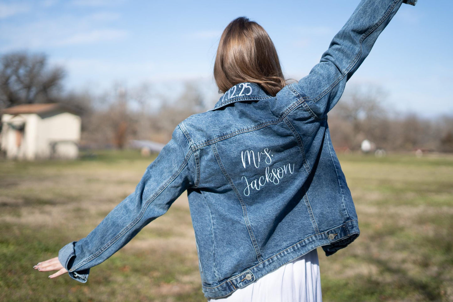 a woman wearing a jean jacket with a name on it
