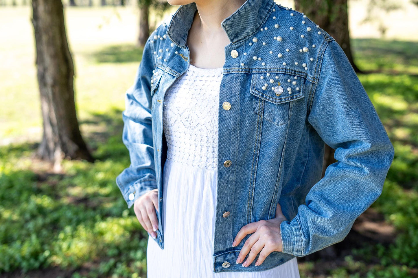 a woman in a white dress and jean jacket