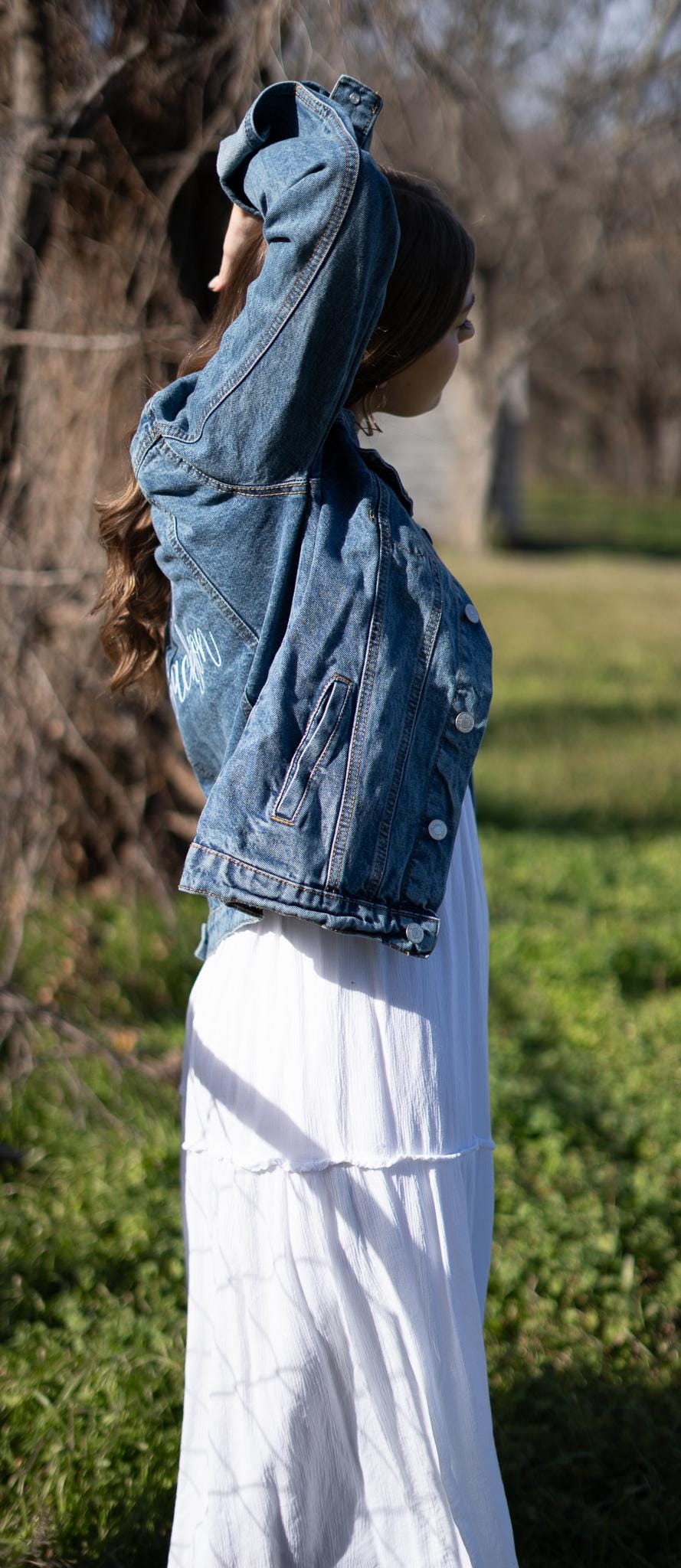 a woman in a white dress and jean jacket