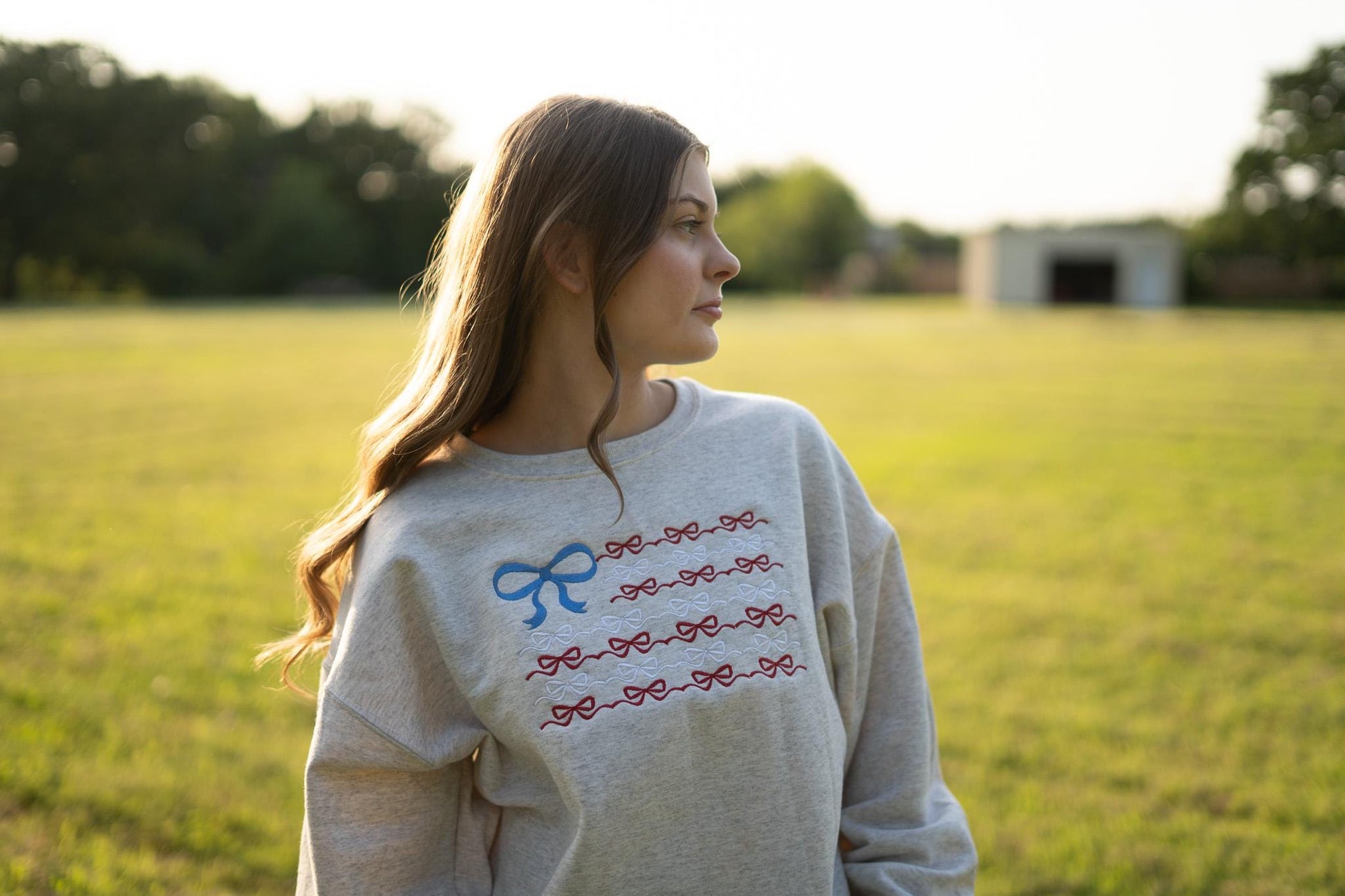 a woman standing in a field with a frisbee in her hand