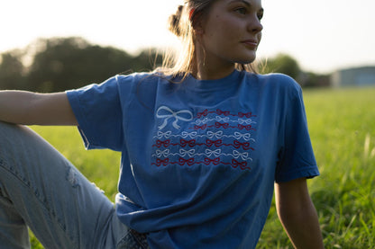 a woman sitting in the grass with her hand on her hip