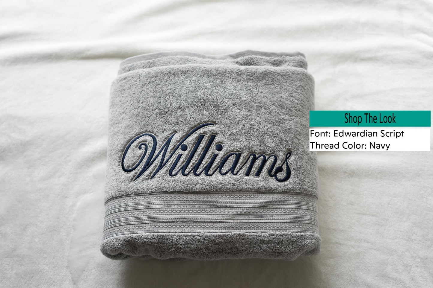 a towel with a name on it sitting on a bed