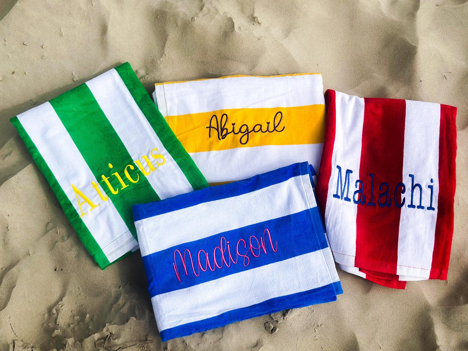 three beach towels with the names of different countries on them
